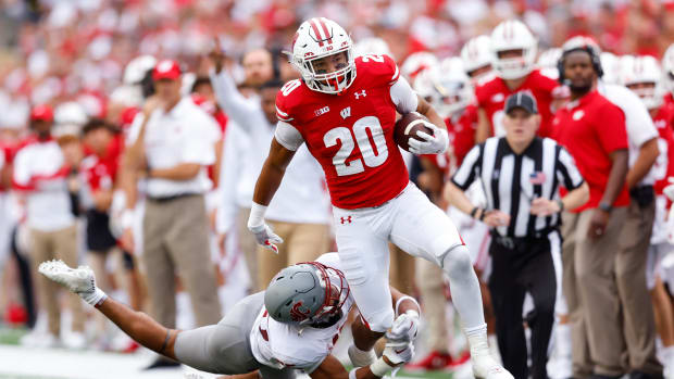Wisconsin running back Isaac Guerendo running with the football down the sideline against Washington State.